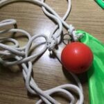Close-up of Suzakoo rubber fitness ball with rope for conditioning exercises.