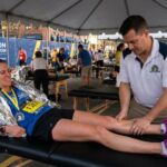 Athlete receiving post-marathon sports massage to relieve muscle soreness