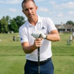 Golfer demonstrating proper hand placement and grip pressure on a golf club