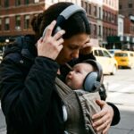 Parent pushing baby stroller on uneven city sidewalk